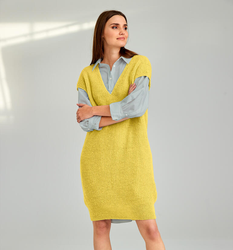 Frau trägt ein knielanges gelbes Kleid aus Strick, modisch.