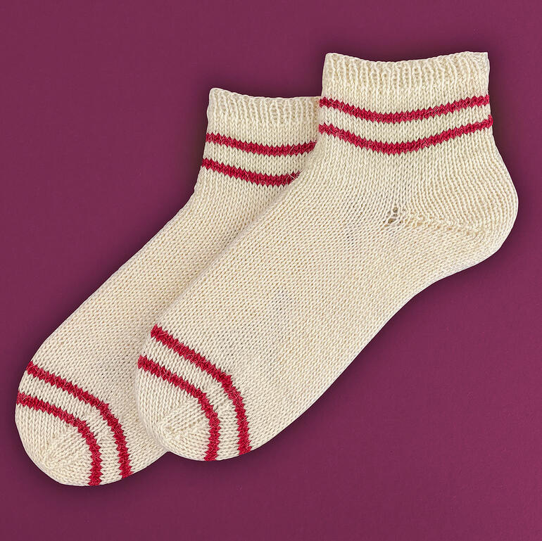 Paar kurze Sneakersocken in Creme mit roten Streifen.