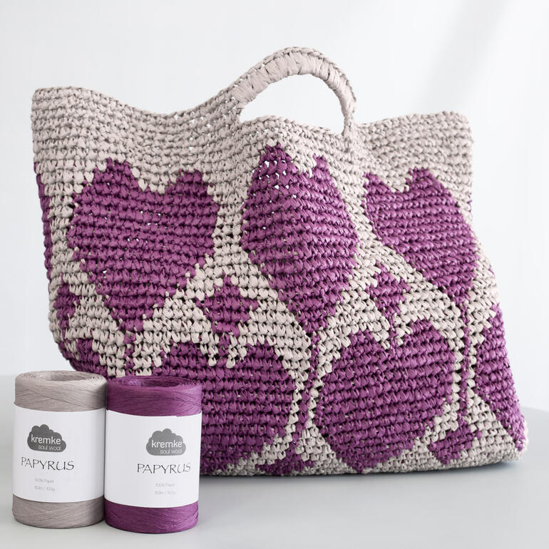 Gestrickter Shopper mit Herz-Muster in lila und beige.