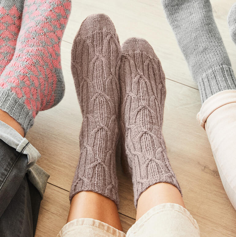 Graue Socken mit strukturierter Oberfläche aus Merino-Freizeit Wolle, auf einem hellen Boden