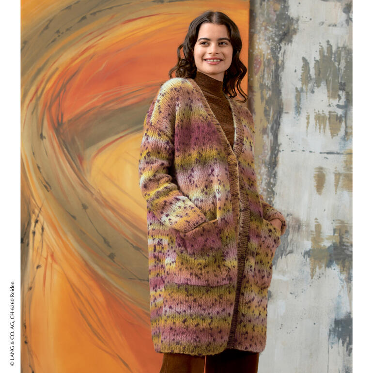 Frau trägt eine lange Jacke aus Cloud Tweed in sanften Farben, vor kreativem Hintergrund