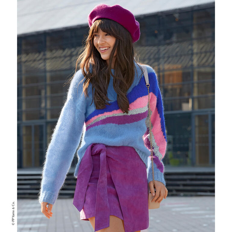 Pullover aus Phil Chic mit gestreiftem Design und lächelnder Frau in einer Stadt.