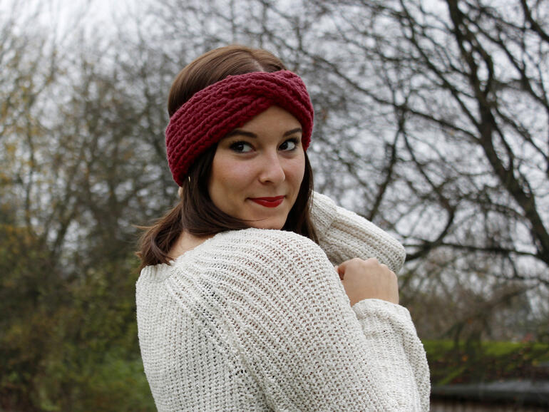 Frau trägt ein rotes Stirnband aus No. 1, blickt zur Seite.