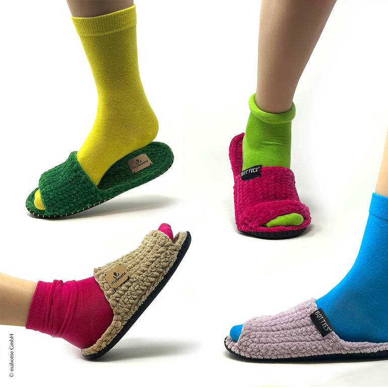 Drei Paare Füße in myboshi-Boshiletten aus Samt, verschiedene Farben.