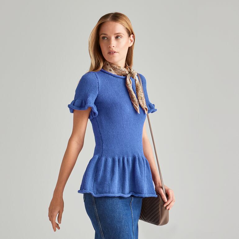 Frau im blauen Pulli aus Merino-Cotton in lässiger Pose.