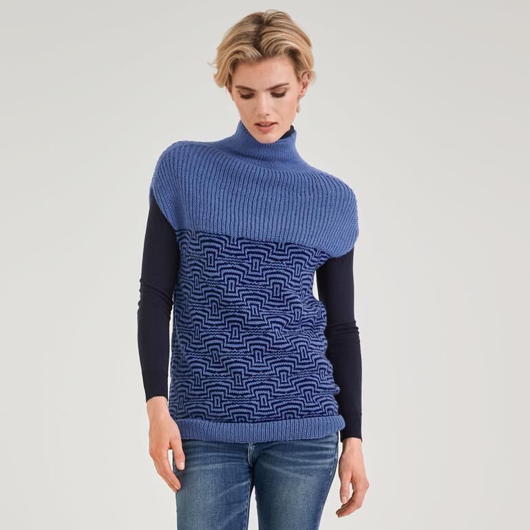 Frau trägt einen langen Pullunder mit Stehkragen in blauer Farbe.