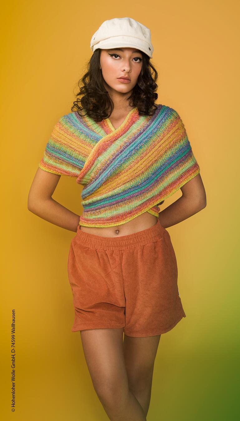 Frau trägt einen bunten Möbius-Loop vor einem gelben Hintergrund.