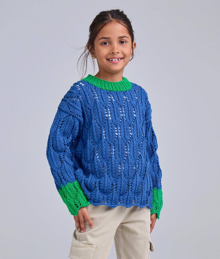 Junge in einem bunten Kinderpullover mit geflochtenen Mustern.