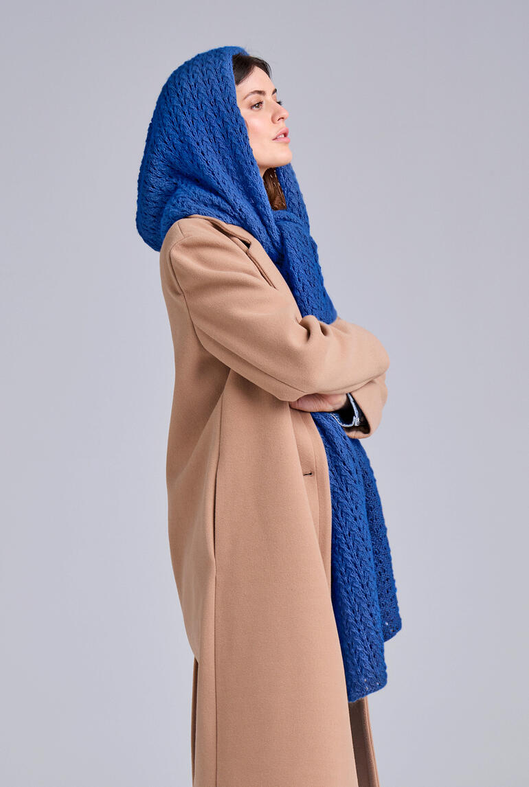 Kapuzenschal aus Fenella in Blau, getragen von einer Frau in beigem Mantel.