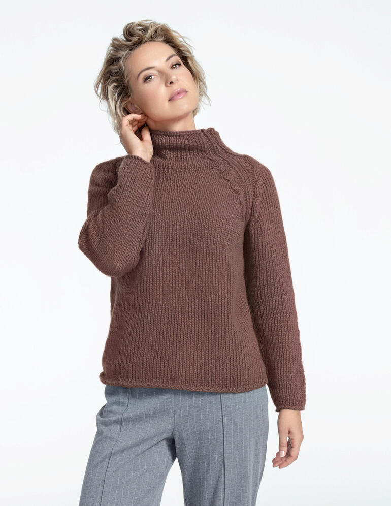 Pullover aus NewWool in Braun mit hohem Kragen, getragen von einer Frau.