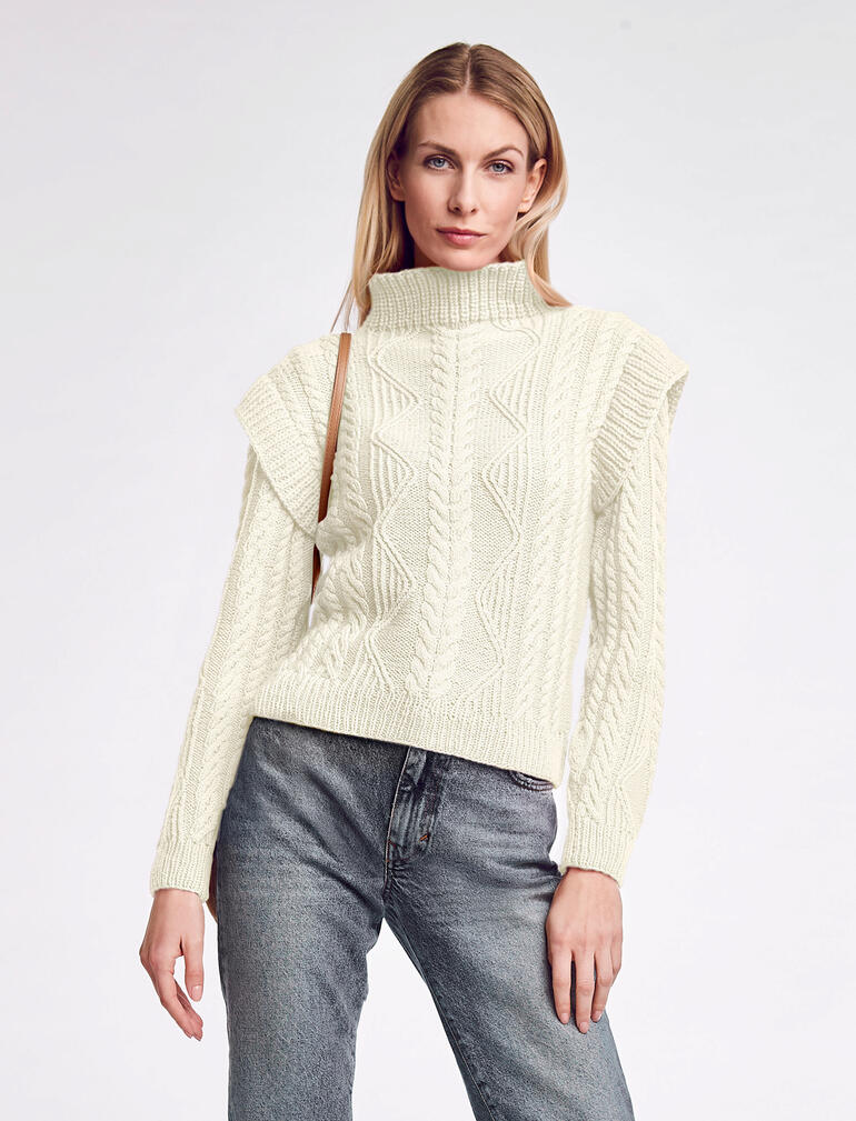 Pullover aus Inja in Creme mit strukturierten Mustern, getragen von einer Frau.