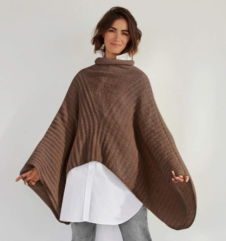 Poncho aus Palazzo in Braun, getragen von einer Frau mit lockigem Haar.