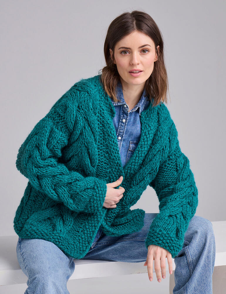 Übergroße, grüne Jacke aus dicker Wolle mit Kabelstrickmuster.