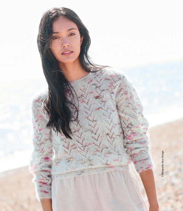 Frau in pastellfarbenem Pullover aus Mohair am Strand.