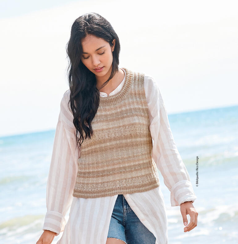 Frau in gestreiftem Top aus Cotton Merino Lace am Strand.