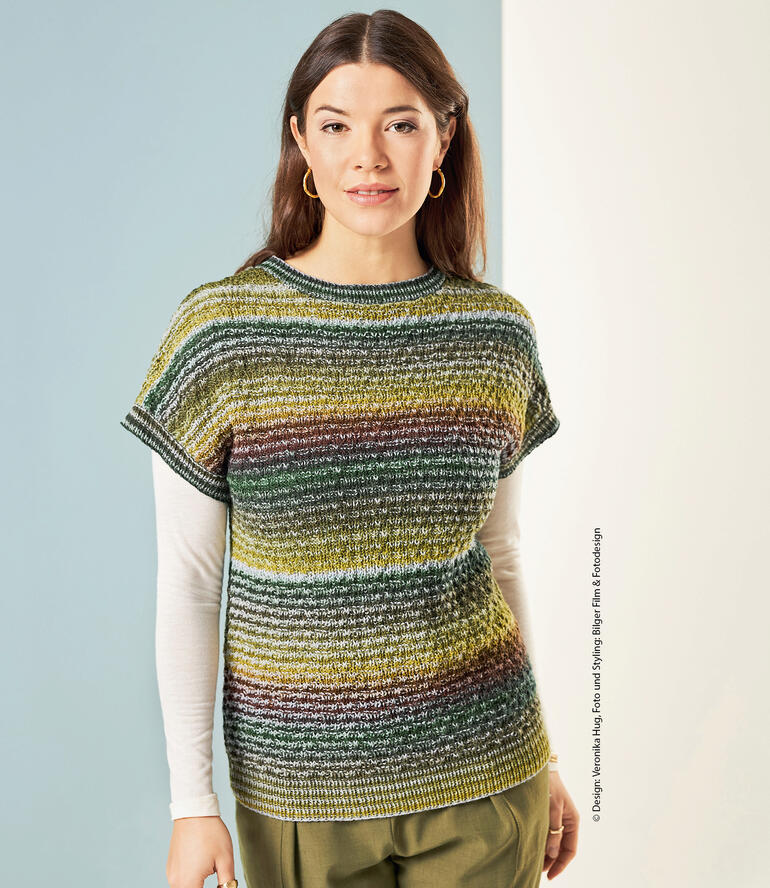 Frau trägt einen gestreiften Pullover in Grüntönen.