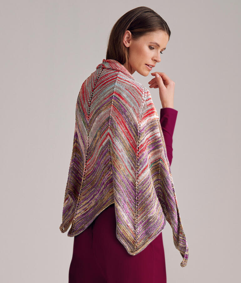 Frau trägt halbrundes Tuch in bunten Farben über der Schulter.