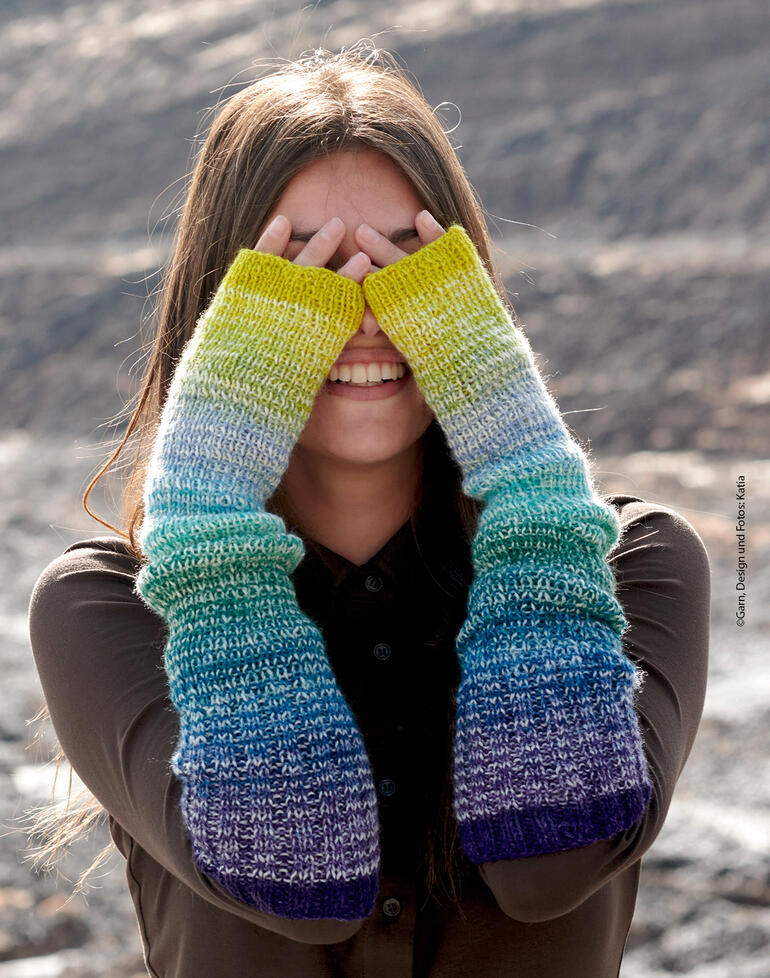Frau in bunten Armstulpen aus Symmetric Socks & More Rainbow, die die Augen verdeckt.