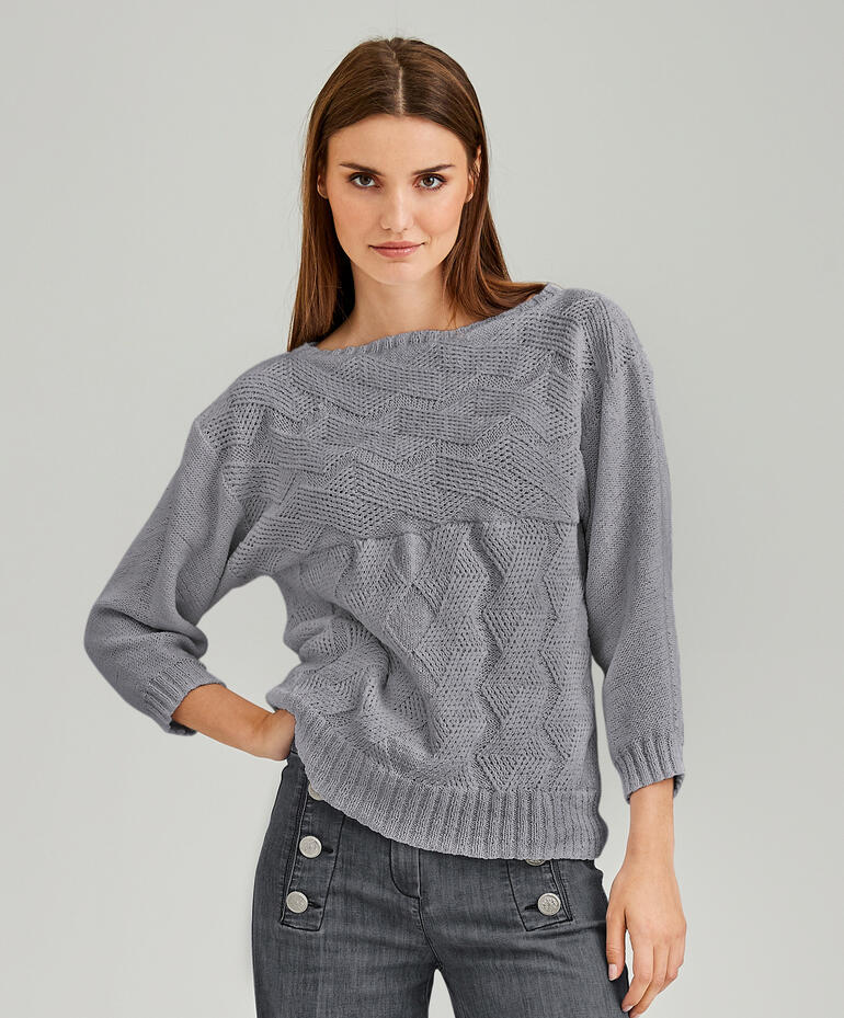 Frau in grauem Pullover aus Recycle & PET mit modischem Design.