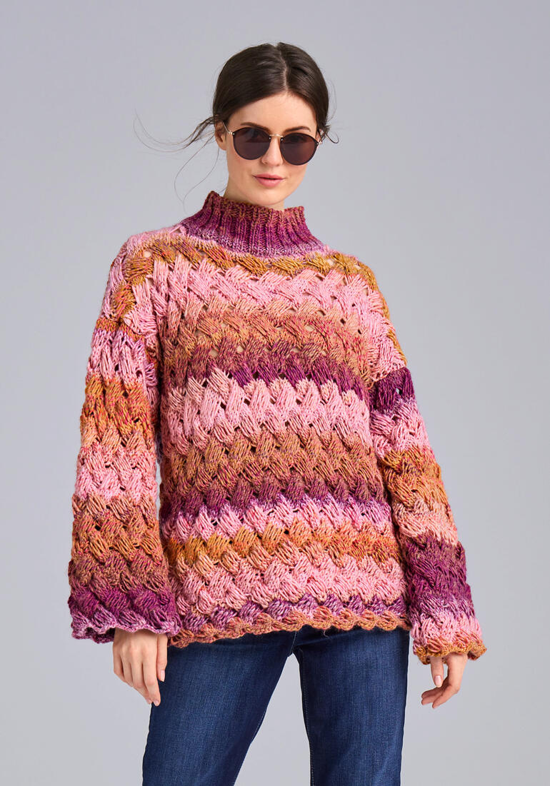 Frau in buntem Pullover aus Monello-90 Color mit weiten Ärmeln.