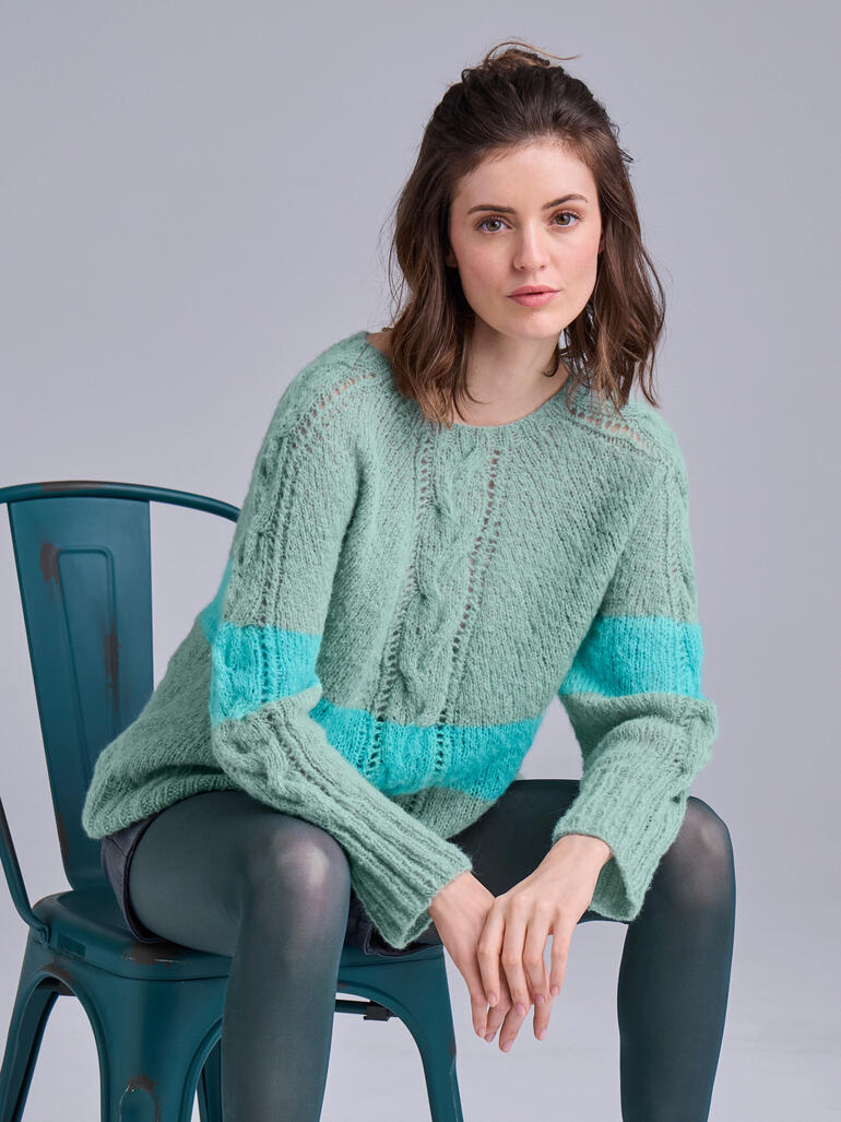 Frau in mintgrünem Pullover aus Aerea mit modernen Streifen.