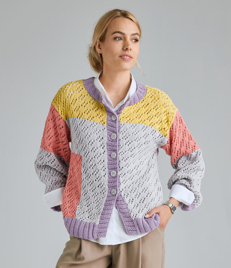 Bunte Jacke aus Cotonia-Mezzo mit Knöpfen, getragen von einer Frau, vor neutralem Hintergrund.