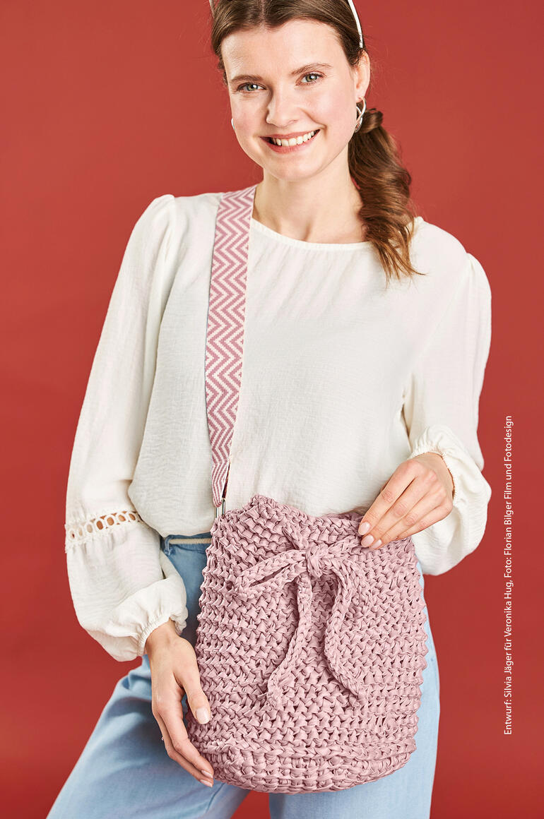 Frau mit Tasche aus Lederlook auf rotem Hintergrund