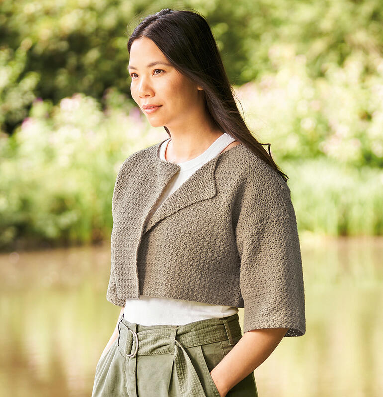 Frau in Häkeljacke aus Cotton Revive am Wasser