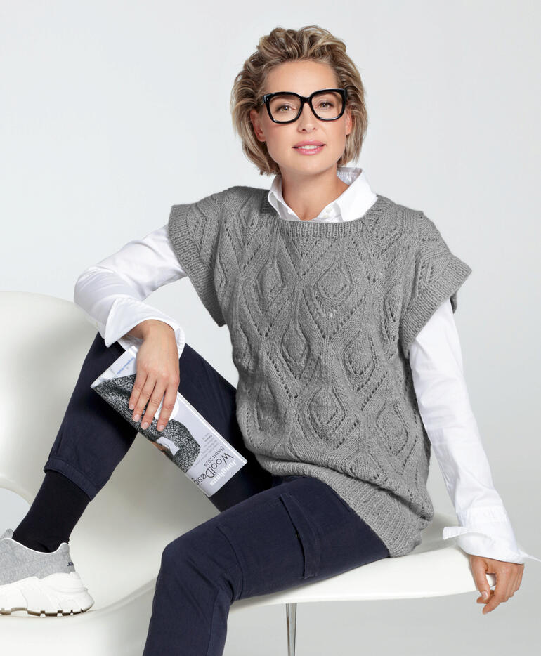 Frau in Pullunder aus Fenella von Junghans-Wolle in einem modernen Raum