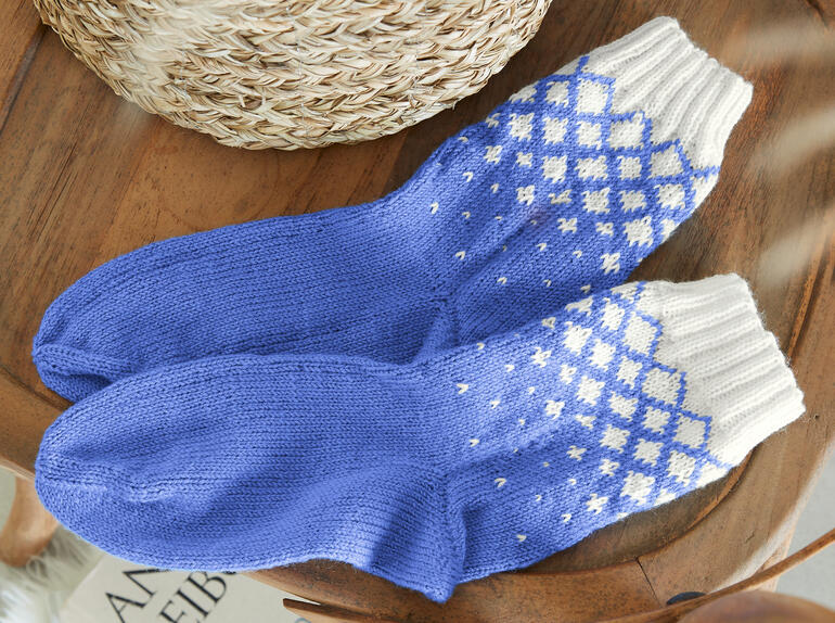Socken in Blau und Weiß mit Karomuster und Zopfmuster.