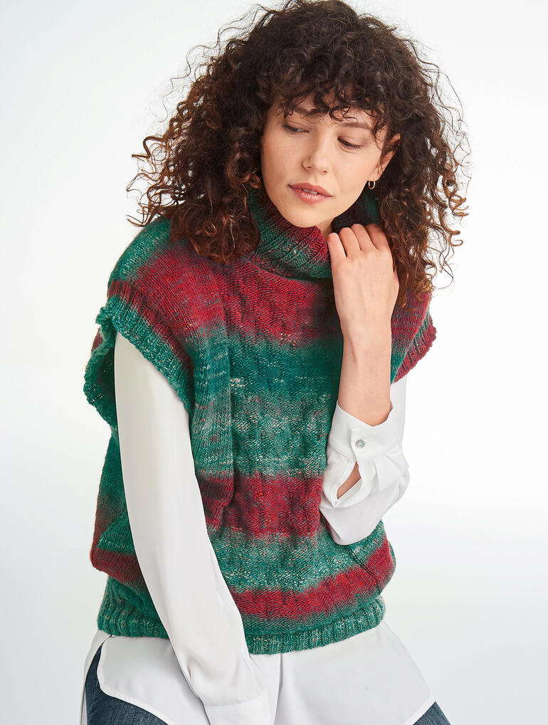 Roter und grüner Pullunder aus Monello-175 Color, getragen von einer Frau mit lockigen Haaren.