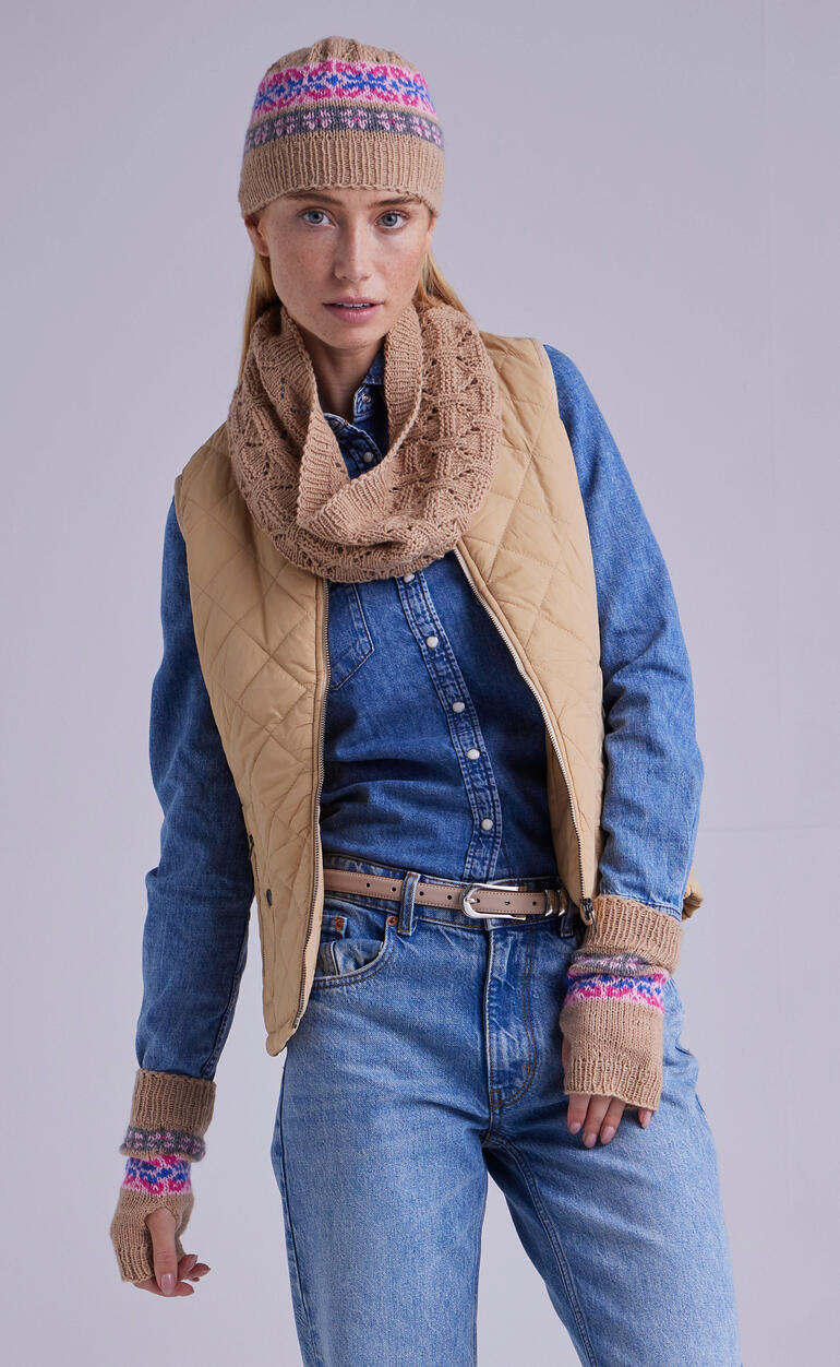 Frau trägt Loop, Mütze und Pulswärmer aus Kaschmir von Junghans-Wolle.