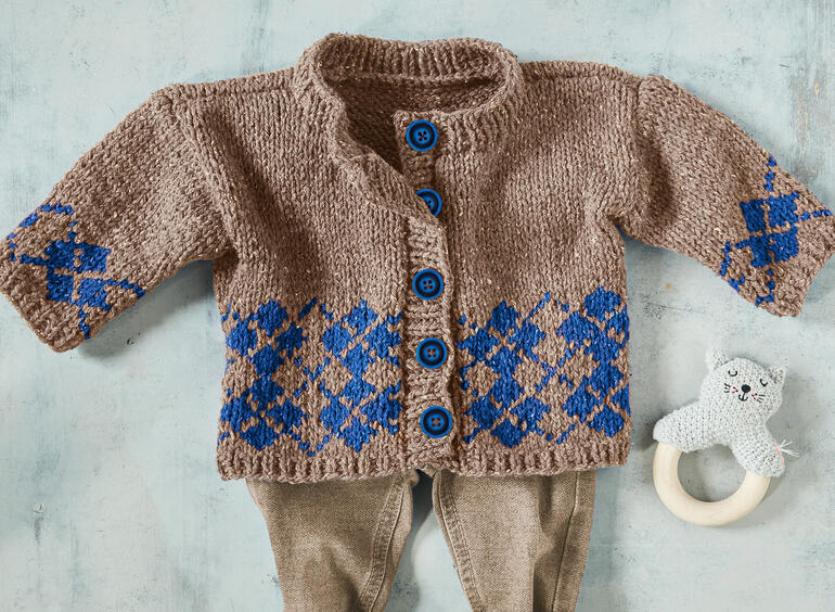 Baby-Jacke aus Punktino mit buntem Muster und Knöpfen in der Mitte.