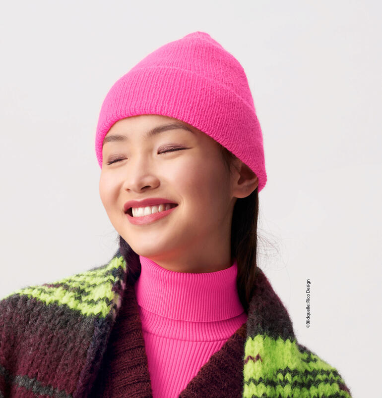 Frau trägt eine leuchtend pinke Mütze aus Socks Neon von Rico Design.