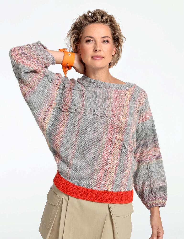 Frau Modell in einem bunten Pullover aus Monello-175 Color und Uni von Junghans-Wolle.