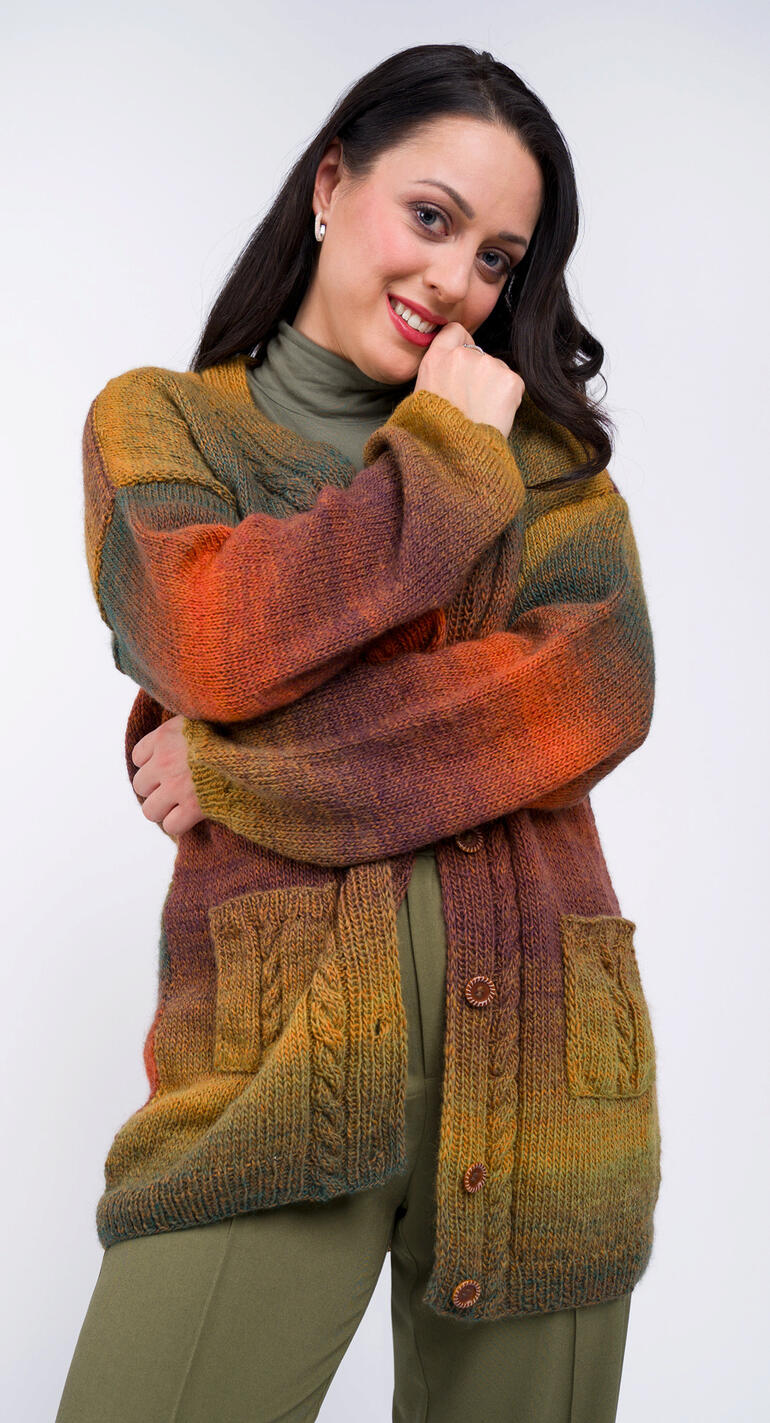 Frau in farbiger Jacke mit Taschen steht lächelnd auf neutralem Hintergrund.