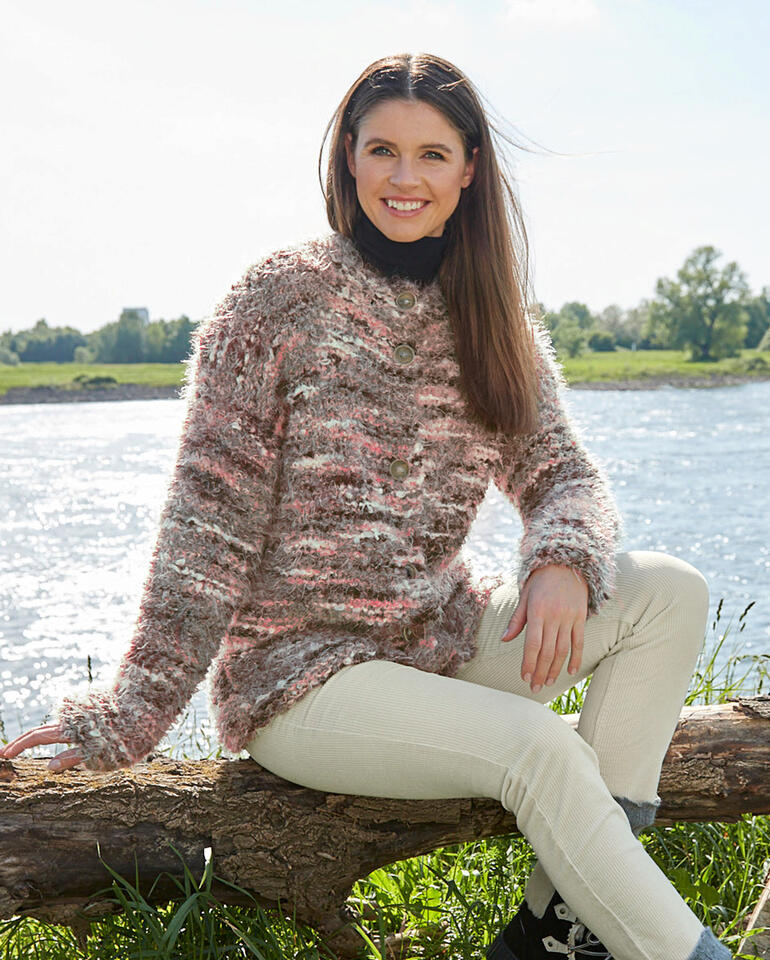 Bunte Jacke aus Bo. und Nuovo Merino 120, lässig am Fluss getragen, mit lässigem Lächeln.