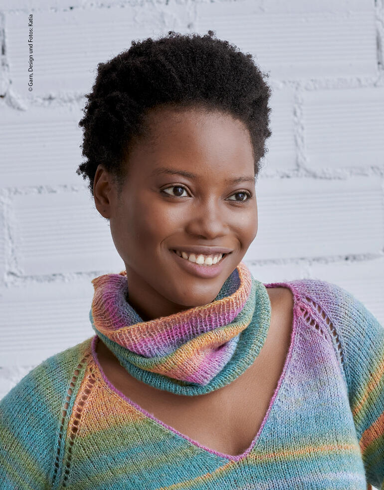 Lächelnde Frau in mehrfarbigem Schal, der um ihren Hals drapiert ist.