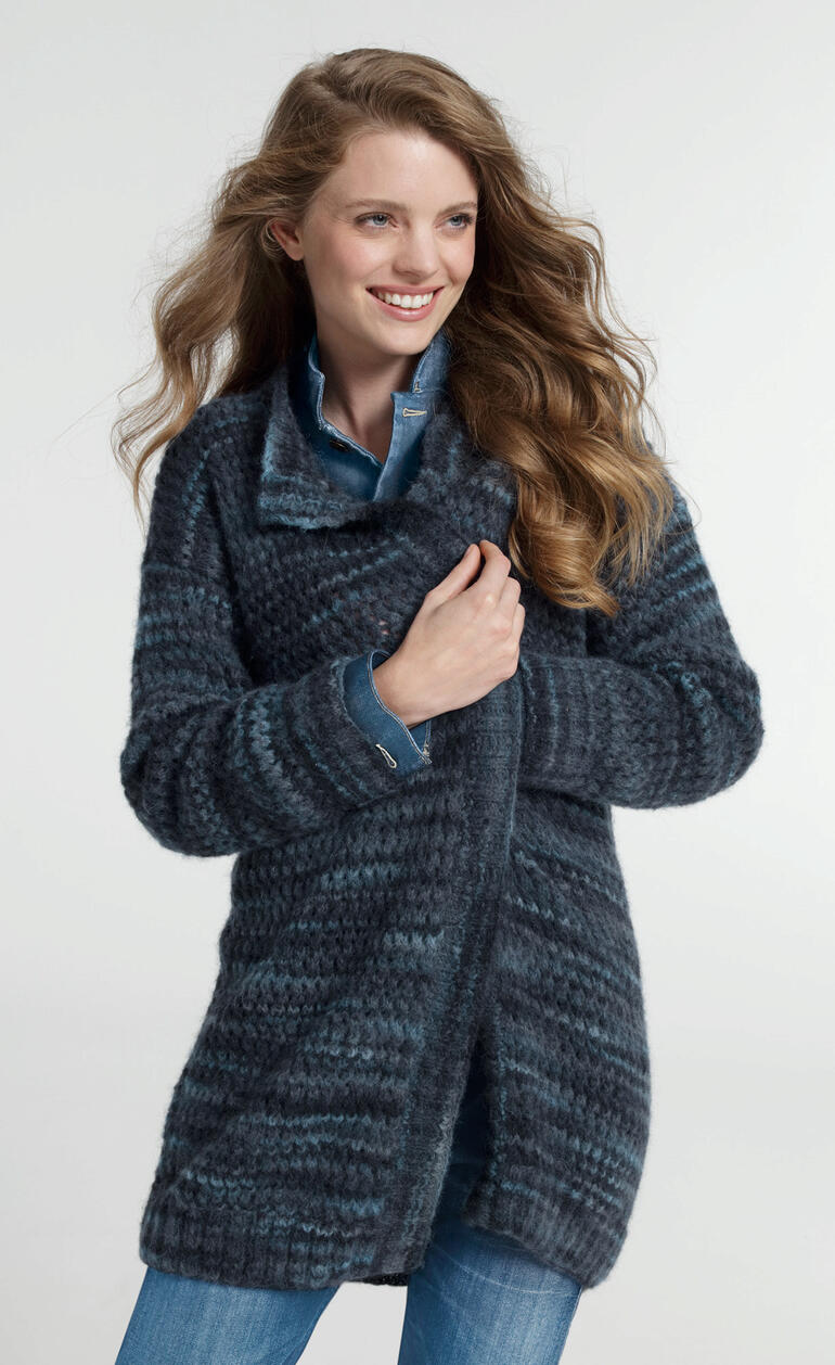 Frau trägt eine melierte, graue Jacke aus leichtem Flou-Material in lässiger Pose.