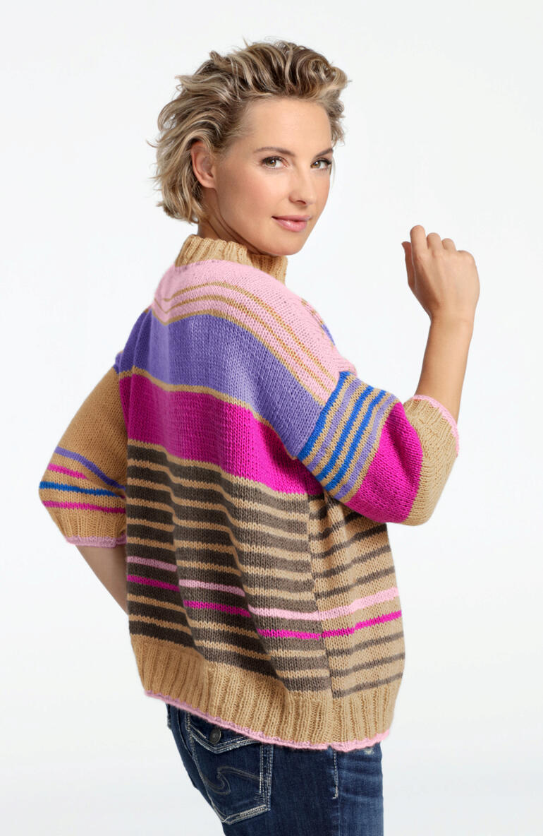 Frau in farbenfrohem Kaschmir-Pullover von hinten, in lässiger Pose.