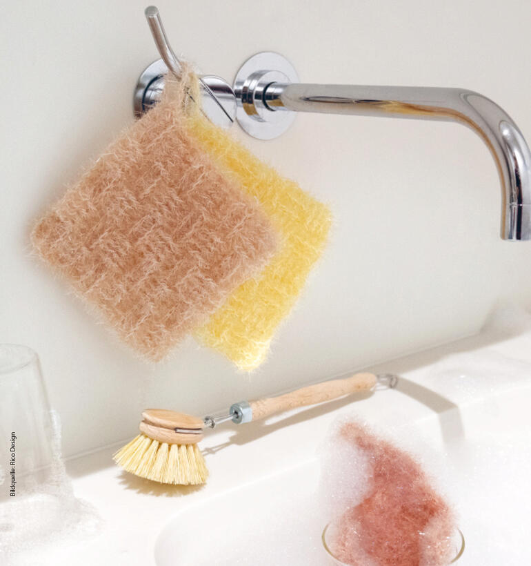 Zwei Spülschwämme aus Creative Bubble hängen an einem Wasserhahn.