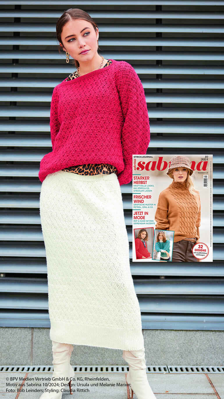 Frau trägt einen roten Pulli und einen weißen Rock aus Nuovo Merino 120 von Junghans-Wolle.