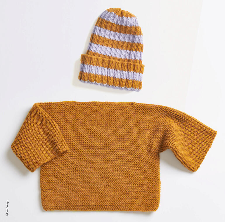 Brauner Babypullover und gestreifte Mütze liegen auf einem Tisch.