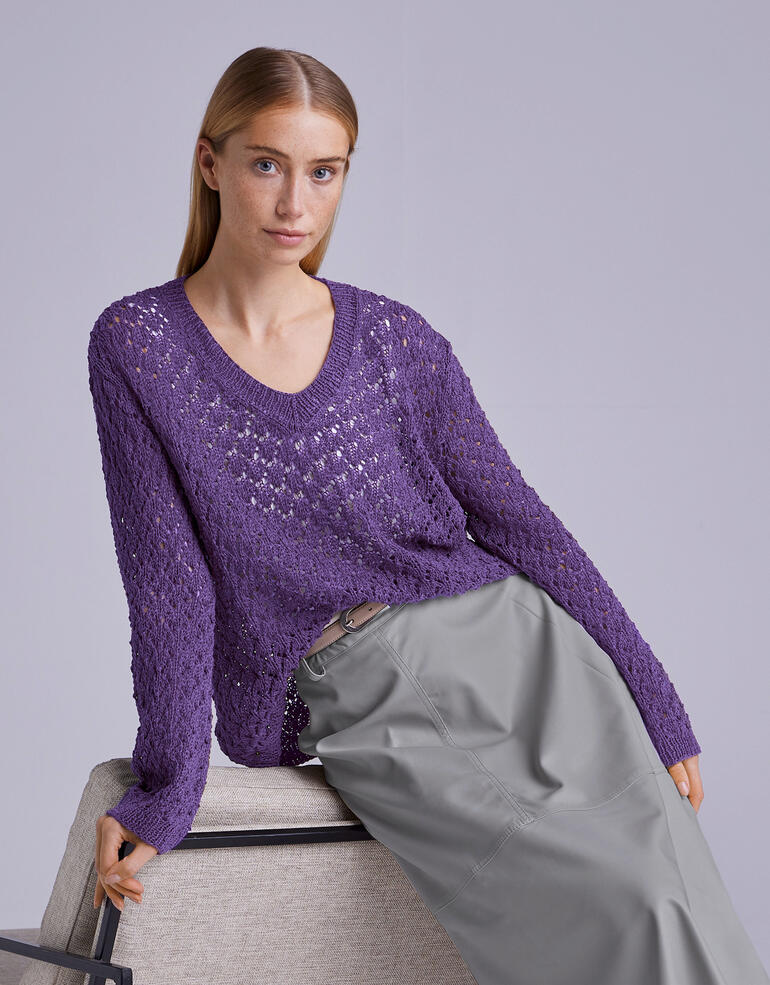 Lila Pullover mit V-Ausschnitt und langen Ärmeln, getragen von einer Frau mit schlichten Jeans.