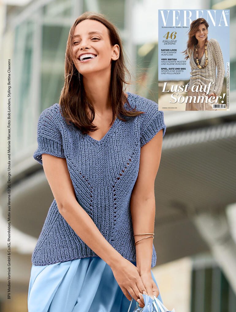 Pulli mit kurzem Arm in sanften Blautönen, getragen von einer Frau, lächelnd in urbanem Umfeld.