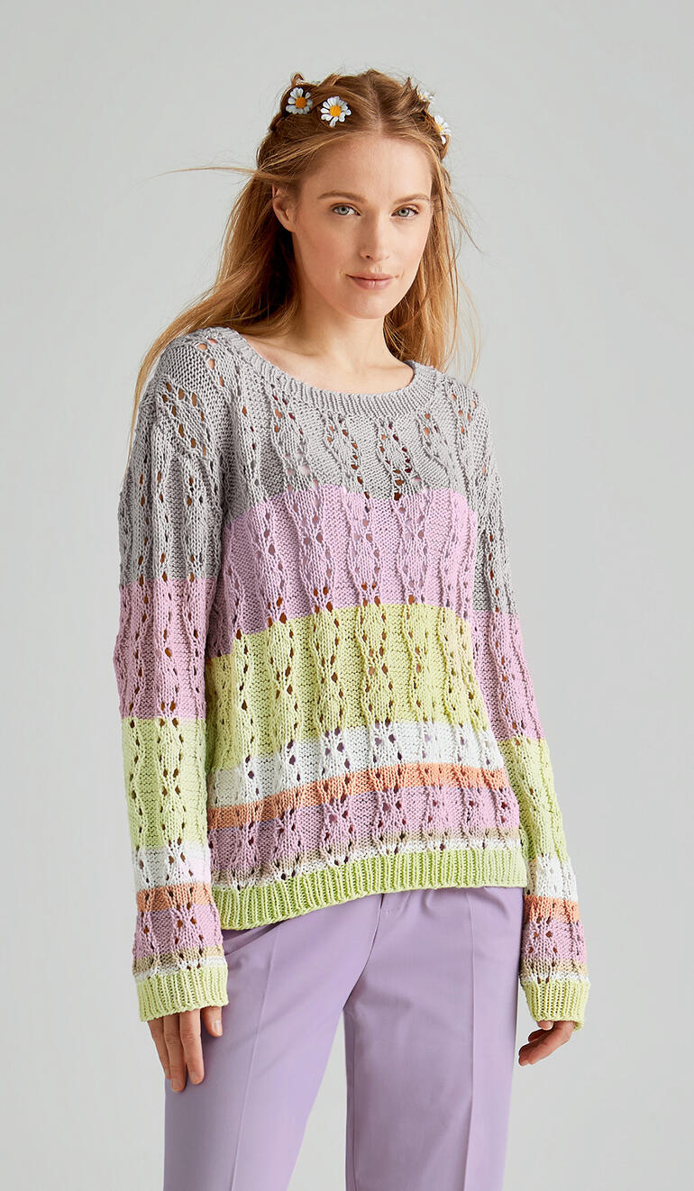 Luftiger Pullover in Zickzack-Muster, getragen von einer Frau mit sanften Farben.