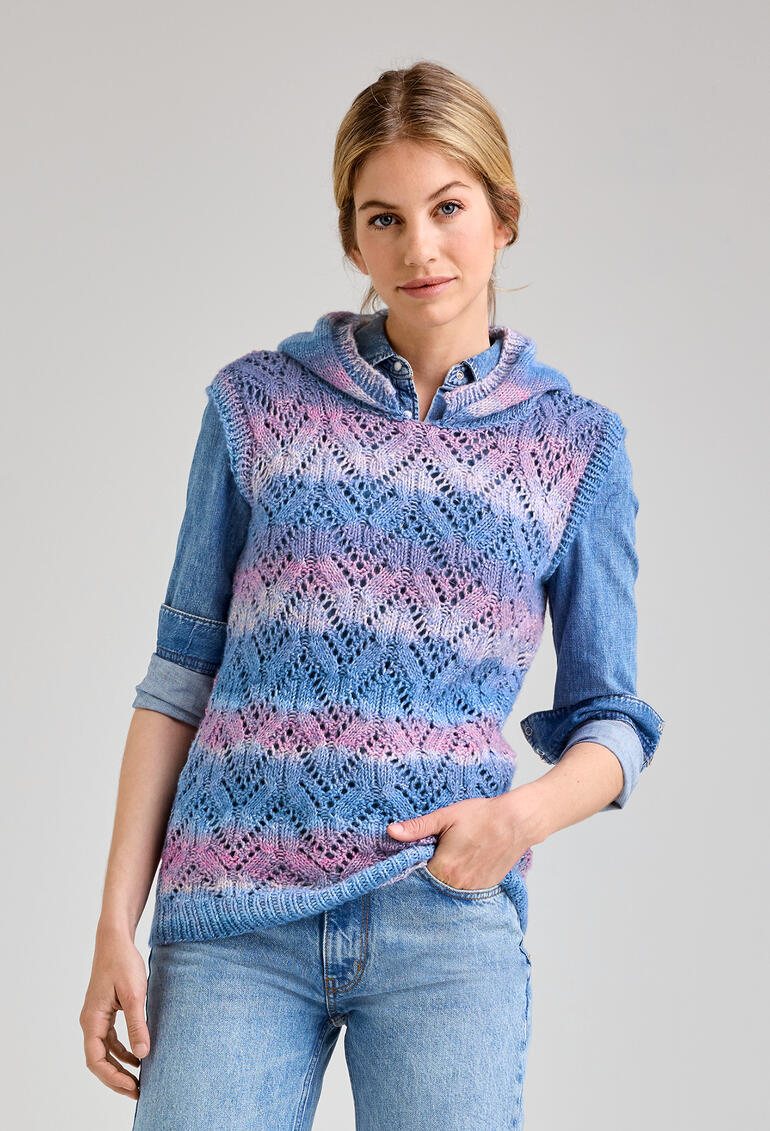 Frau in einem bunten Kapuzenpullunder aus Lotti-Colori, lächelnd, in Jeans