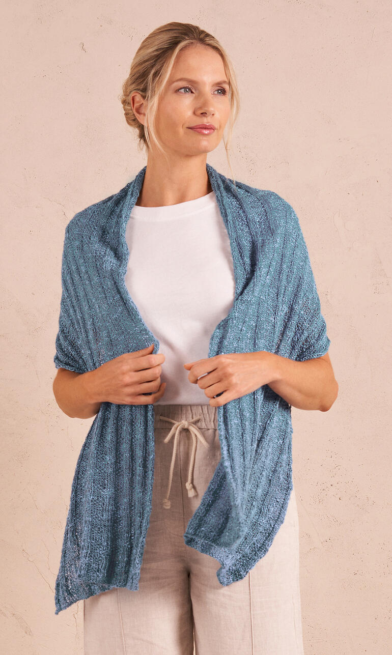 Blauer Schal aus Natura Linen, getragen von einer Frau in heller Kleidung.