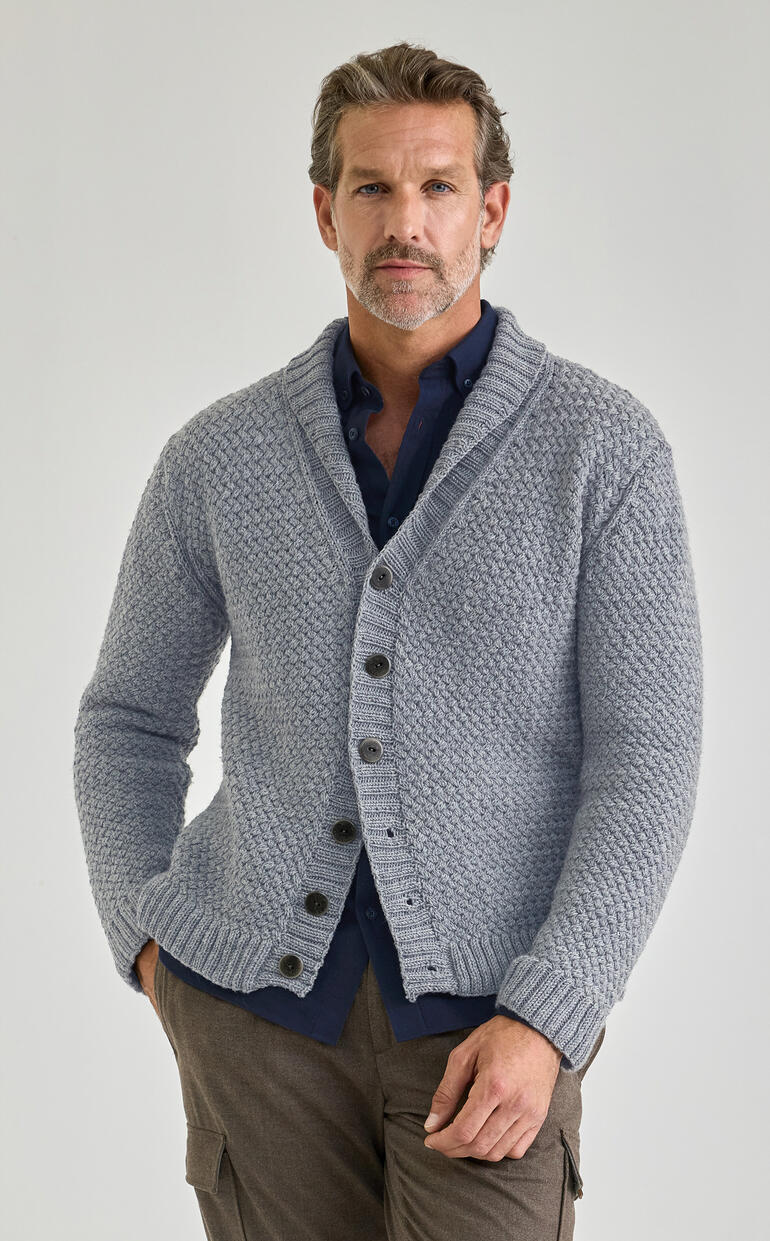 Mann trägt graue Merino-Jacke mit Knöpfen und einem dunkelblauen Hemd darunter.