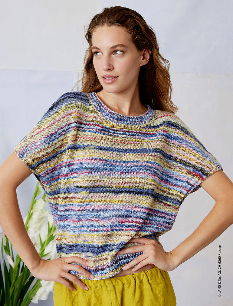 Frau in einem Pullunder aus Fiesta von LANG Yarns, steht vor einem hellen Hintergrund.